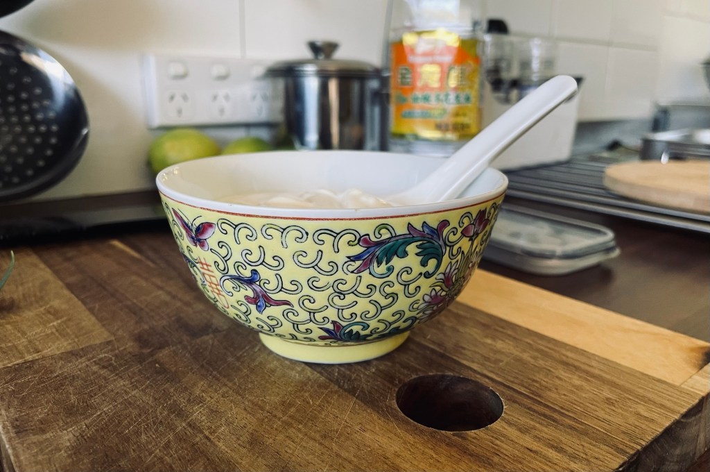 Chinese rice bowl with yellow pattern and a spoon inside