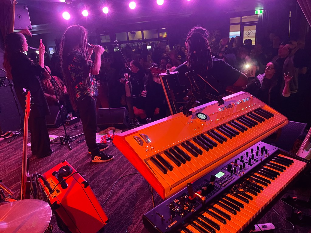 Arturia Astrolab keyboard and Yamaha YC 61 stage organ on a stage in Brisbane, Australia. People dancing in the background.